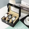 A black watch organizer box with a clear lid, displaying three watches inside. Náhľad obrázku produktu