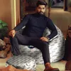 A man is sitting on a bean bag chair in a modern living room setting. Náhled obrázku produktu