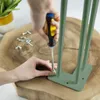 A person is screwing a hairpin leg onto a wooden surface. Podgląd zdjęcia produktu