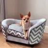 A small dog is sitting on a pet bed in a room. Náhled obrázku produktu