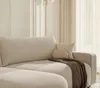 A close-up view of a sectional sofa with a throw blanket and pillows. Voir les images du produit
