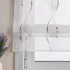 A close-up of a white Roman blind with a brown embroidered pattern hanging in front of a window. A vase of lavender is visible to the left. Produktbild-Vorschau