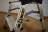 A close-up shot of a two-step foldable aluminum stepladder. Podgląd zdjęcia produktu