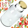 A clear glass jar with a gold lid is shown tilted, surrounded by various fresh vegetables and herbs. Podgląd zdjęcia produktu