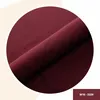 A close-up, circular crop of a burgundy fabric product. A small rectangle in the bottom right corner contains text. Anteprima dell’immagine prodotto