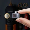 A hand holding a small thermal camera, with a coin for scale. Voir les images du produit
