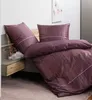 A bed with purple and pink striped bedding. Produktbild-Vorschau