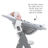 A baby is sitting in a high chair accessory. Produktbild-Vorschau