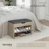 A shoe bench with shoes and accessories stored inside, placed next to a bed in a bedroom. Náhled obrázku produktu
