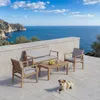 A patio set with a sofa, two chairs, and a coffee table is placed on a tiled patio overlooking the ocean. A dog is lying on the patio. Voir les images du produit