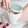 A person is opening a container of ice cream with raspberries. Produktbild-Vorschau