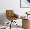 A brown armchair is placed in a room with a small wooden table and a vase of flowers. Produktbild-Vorschau