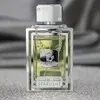 A bottle of perfume is displayed against a blurred background. Produktbild-Vorschau