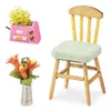 A collection of miniature items including a pink toaster with yellow greenery, a vase with orange flowers, and a wooden chair with a light green cushion, all on a white background. Náhled obrázku produktu