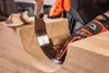 A person wearing gloves is using a Japanese saw to cut a piece of wood. Produktbild-Vorschau
