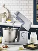A kitchen counter with a stand mixer, ingredients, and baked goods. Produktbild-Vorschau