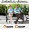 A couple sitting on a garden bench outdoors. Anteprima dell’immagine prodotto