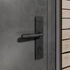 A close-up view of a dark gray door handle and lock mechanism. Produktbild-Vorschau