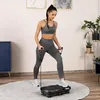 A woman is exercising on a vibration plate in a room. Produktbild-Vorschau