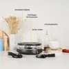 A raclette grill and accessories are displayed on a kitchen counter with decorative elements. Anteprima dell’immagine prodotto