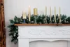 A Christmas garland with candles on a mantelpiece. Anteprima dell’immagine prodotto