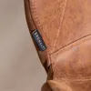 A close-up of a brown leather tag on a brown leather chair. Produktbild-Vorschau