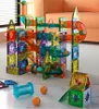 A marble run toy set constructed from colorful magnetic blocks and tubes, set up on a floor with a couch in the background. Náhľad obrázku produktu