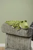 A stuffed toy crocodile is lying on a woven bench. Podgląd zdjęcia produktu