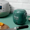 Two rice cookers on a kitchen counter with some cheese and a knife. Produktbild-Vorschau