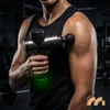 A person in a gym holding a massage gun. Produktbild-Vorschau