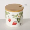 A ceramic jar with a strawberry design and a bamboo lid with a spoon. Produktbild-Vorschau