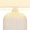 Close-up of the top part of a table lamp, showing the lampshade and the textured glass base. Anteprima dell’immagine prodotto