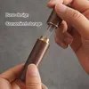 Hands holding a small wooden container with metal needles sticking out, with text overlays indicating its features. Produktbild-Vorschau