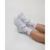 A person's legs wearing white Nike socks and white Nike P-6000 running trainers, against a white background. Produktbild-Vorschau