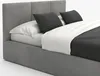 A studio shot of a gray upholstered bed with white and dark gray bedding and pillows. Náhled obrázku produktu