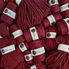 A pile of spools of burgundy yarn. Náhled obrázku produktu