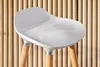 A close-up of a white bar stool with wooden legs against a slatted wooden background. Produktbild-Vorschau
