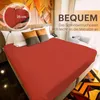 A bed with a red fitted sheet, pillows, and a headboard with abstract art. Produktbild-Vorschau