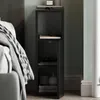 A black nightstand next to a bed. Náhľad obrázku produktu