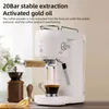 A white espresso machine is shown in action, brewing coffee into a glass cup. A coffee grinder and tamper are visible to the left. Produktbild-Vorschau