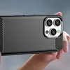 A person's hands are holding a black smartphone case with a carbon fiber texture on the sides and a brushed metal finish on the back. The camera module of the phone is visible. Podgląd zdjęcia produktu