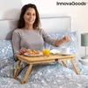 A woman is having breakfast in bed using a portable table. Produktbild-Vorschau