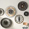 Several decorative wall clocks are displayed on a white brick wall. Náhľad obrázku produktu