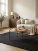 Runder Couchtisch aus Eichenholz mit filigranem Metallgestell als Mittelpunkt einer stilvollen Wohnzimmer-Sitzgruppe auf einem dunklen Teppich vor einem Sofa._#sku_BARWL6.493# Produktbild-Vorschau