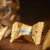 A close-up shot of a golden-wrapped chocolate on a wooden surface. Náhľad obrázku produktu
