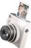 A white Fujifilm Instax Square SQ 1 instant camera with a photo emerging from the top. Produktbild-Vorschau