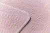 A close-up view of a blanket with a herringbone pattern and a decorative edge. Produktbild-Vorschau