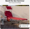 A red Casaria sun lounger with a canopy and side pocket is set up on a wooden deck next to a small table with a drink. Produktbild-Vorschau