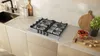 A modern kitchen countertop with a gas hob, sink, and decorative items. Produktbild-Vorschau