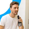 A man is using a water flosser in a bathroom setting. Voir les images du produit